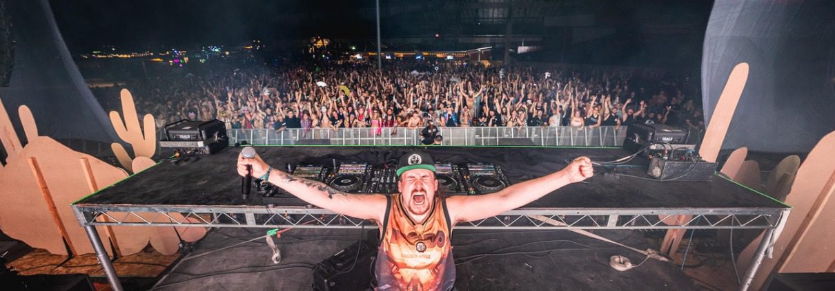 A DJ standing in front of a crowd at Goldrush: Wild Card